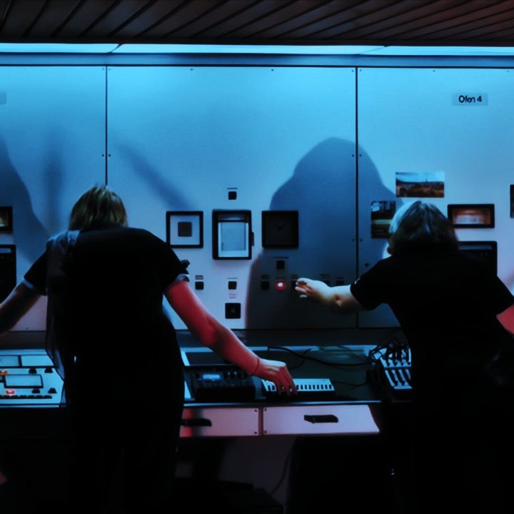 Catenation live, two performers at a blue-lit control panel